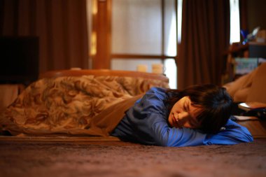 Kotatsu üzerinde uyuyan bir kadın.