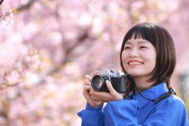 Fotoğraf çeken bir kadının resmi. 