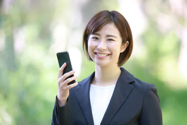 美丽的亚洲女商人 在户外带着智能手机 — 图库照片