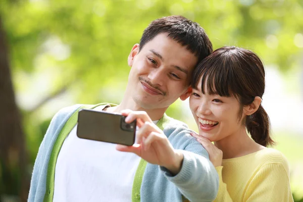 若いカップル公園で携帯電話での撮影 Selfie — ストック写真