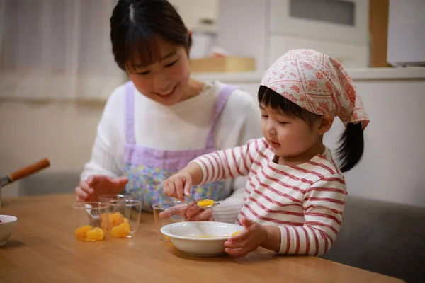美しいですアジアの母料理とともに彼女の小さな娘オンザキッチン — ストック写真