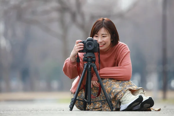 年轻的女摄影师 在街上带着相机 — 图库照片
