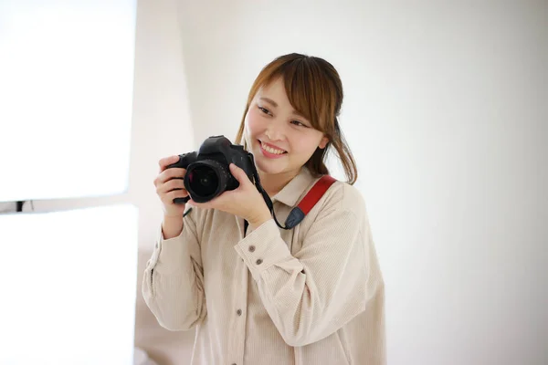 演播室里拿着相机的年轻漂亮的女摄影师 — 图库照片