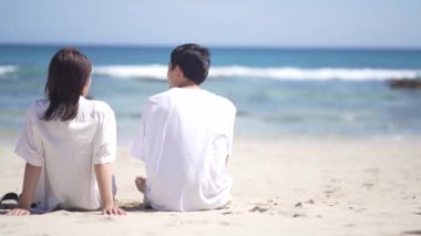 Kumsalda yürüyen bir çift.