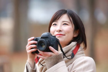 Fotoğraf çeken bir kadının resmi. 