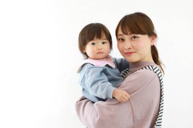 Genç Asyalı anne kızına sarılıyor.