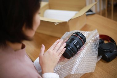 Kadın fotoğrafçı dijital kameranın detaylarını paketliyor