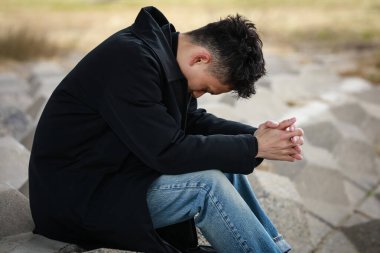 Genç Asyalı adam arka planda akıllı telefon kullanıyor.