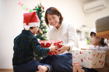 Asyalı anne ve oğlu hediyeleri açıyor.