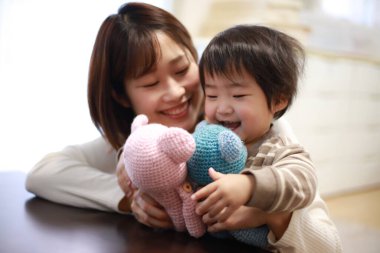 Mutlu Asyalı anne küçük oğluyla oynuyor.