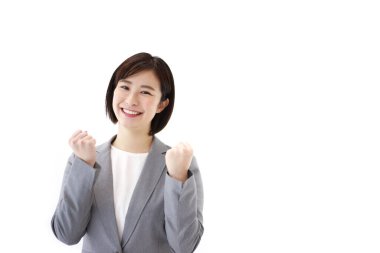 Tecrit edilmiş arka planda yumrukları olan Asyalı genç bir iş kadını. 