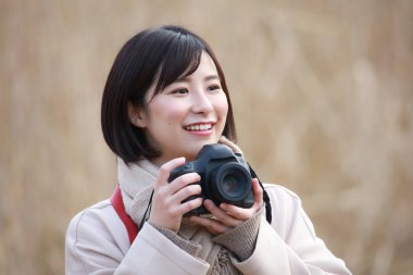 Parkta fotoğraf çeken Asyalı kadın. 