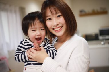 gülümseyen Asyalı genç kadın ve küçük oğlu 