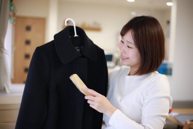 Ceketini fırçalayan bir kadın resmi