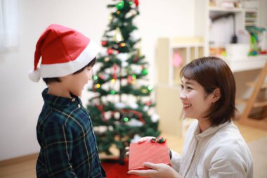 Asyalı anne ve oğlu hediyeleri açıyor.