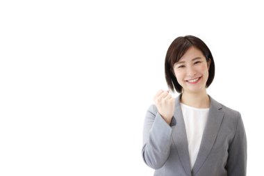 Tecrit edilmiş arka planda yumruğu olan genç Asyalı iş kadını. 