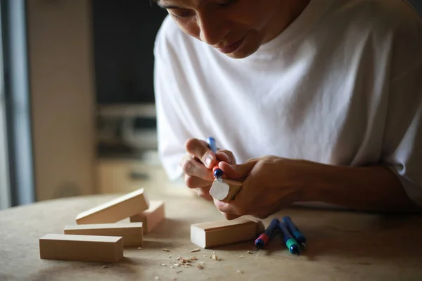男青年木匠 工作台上有木制木块 — 图库照片