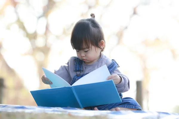 Азиатская Маленькая Девочка Читает Книгу Парке — стоковое фото