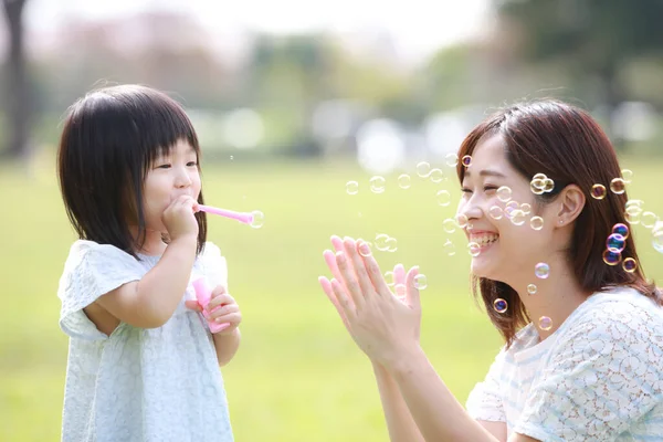 Anne ve küçük tatlı kızı parkta birlikte oynuyorlar.