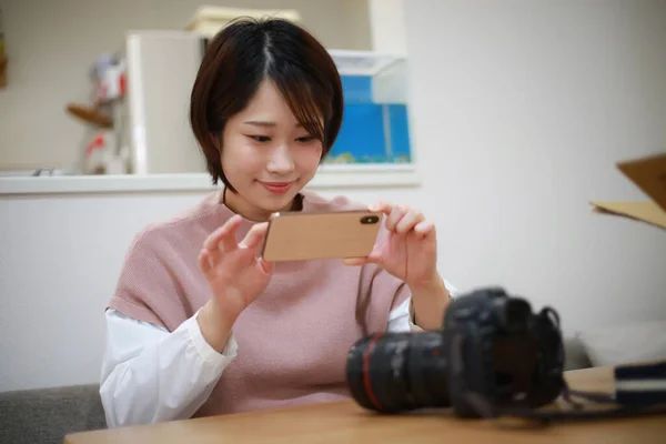 Молодая Азиатка Пользуется Мобильным Телефоном Дома — стоковое фото