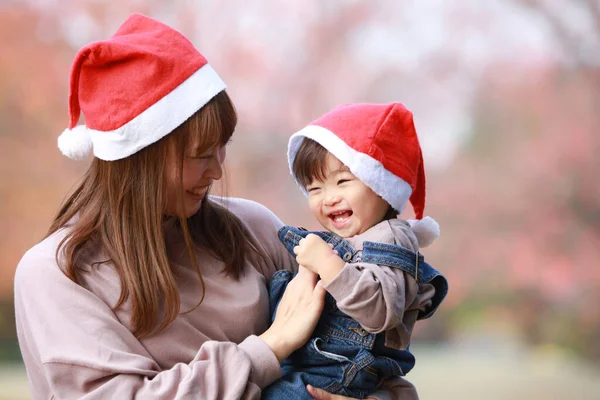 Roztomilý Malý Asijské Dívka Její Maminka Parku Santa Claus Klobouky — Stock fotografie