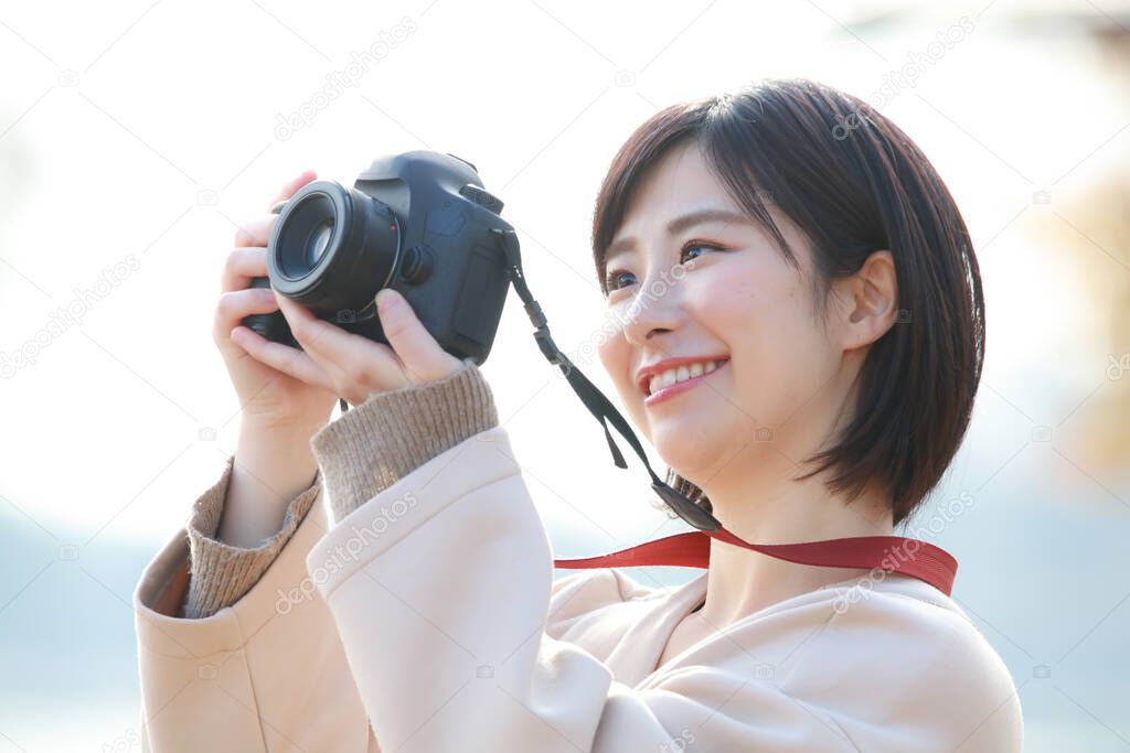 asian woman taking a picture in park 