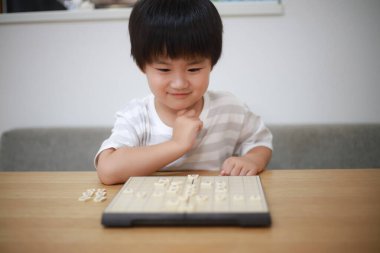 Asyalı çocuk evde oynuyor.