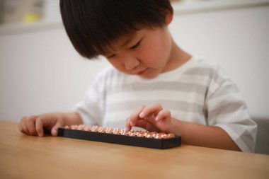 Küçük çocuk evde eğitim oyunu oynuyor. 