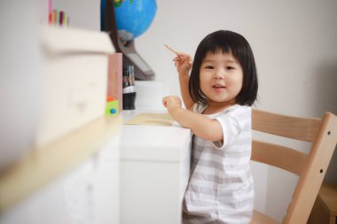 Evdeki kameraya gülümseyen küçük şirin bir kız.