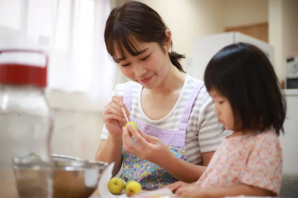 小さな娘と小さなリンゴを持つ若いアジアの女性は — ストック写真