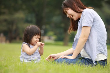 Anne ve kızı parkta oynuyorlar.