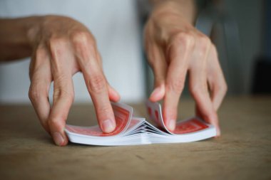 Masada kart oynayan Asyalı adam.