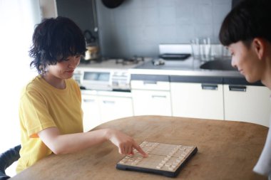 Mutlu Asyalı çift masa oyunu oynuyor.