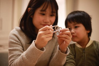 Asyalı genç kadın ve küçük oğlu oynuyorlar. 