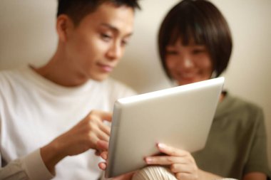 Genç Asyalı çift tablet bilgisayar kullanıyor.