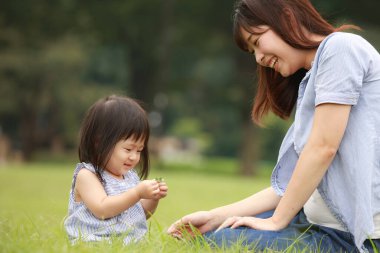 Anne ve kızı parkta oynuyorlar.