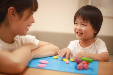 Anne ve oğlu çamurla oynuyor.