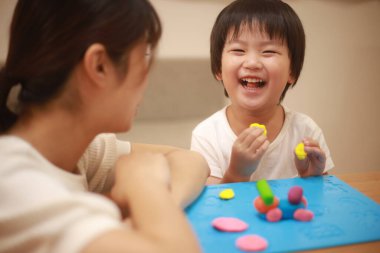 Anne ve oğlu çamurla oynuyor.