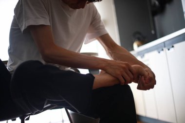 Asyalı adam evinde bacak ağrısı çekiyor.