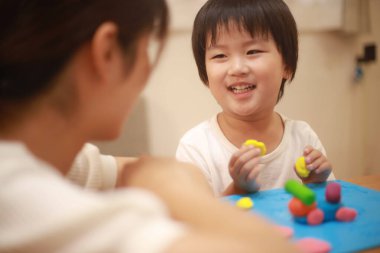 Anne ve oğlu çamurla oynuyor.