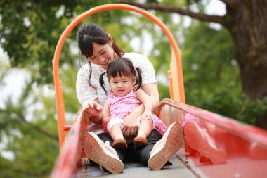 Anne ve kızı oyun alanında oynuyorlar.