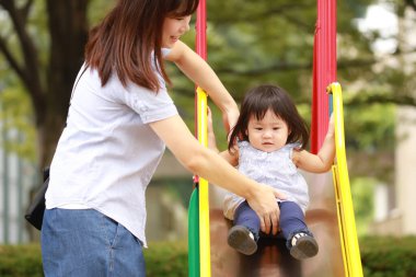 Anne ve kızı oyun alanında oynuyorlar.