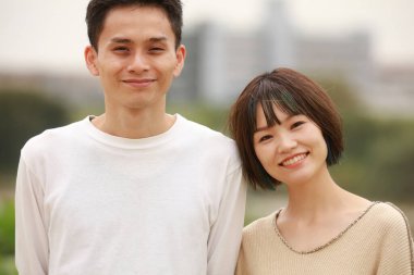 Güneşli bahar gününde parkta duran genç çift