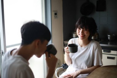 Mutlu genç çift sabahları taze çayın tadını çıkarıyor.