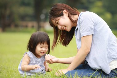 Anne ve kızı parkta oynuyorlar.