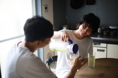 Mutlu genç çift sabahları taze çayın tadını çıkarıyor.