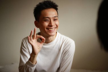 Asyalı adamın portresi tamam işareti gösteriyor