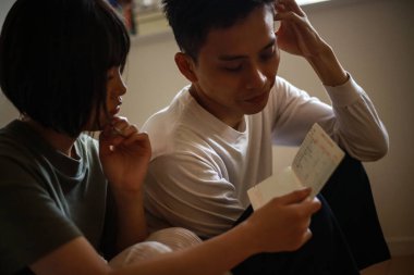 Bir çift hesap defterlerine bakarken endişeleniyor.