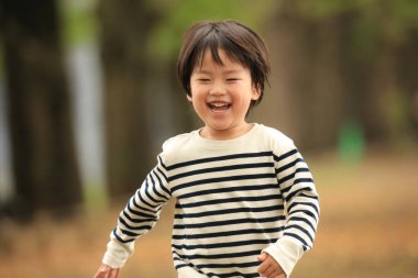 Sonbahar parkında küçük şirin bir çocuğun portresi.