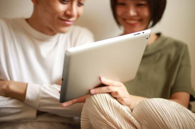 Genç Asyalı çift tablet bilgisayar kullanıyor.